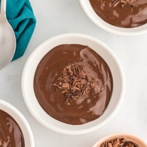 Bowls of rich dairy-free chocolate pudding topped with shaved chocolate, ready to serve.