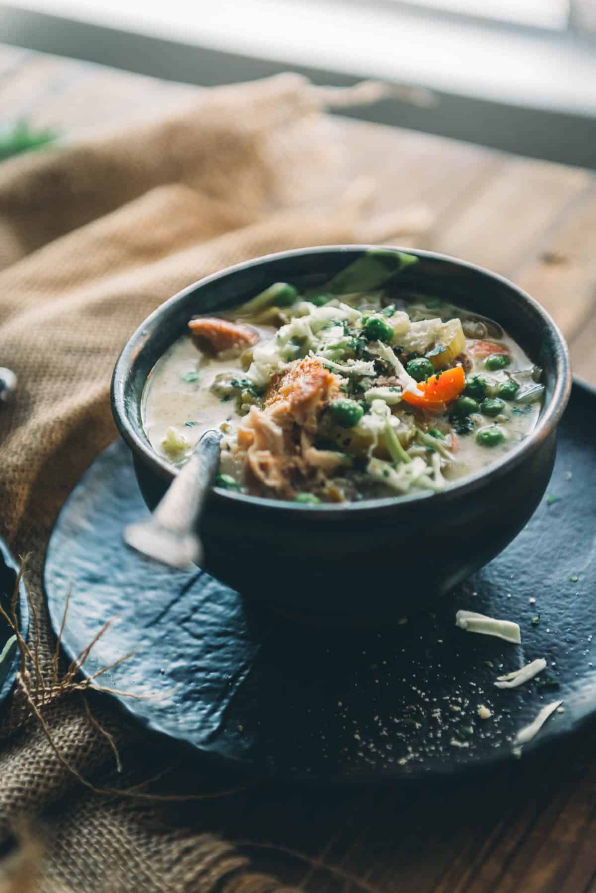 A bowl of soup on a wooden table.