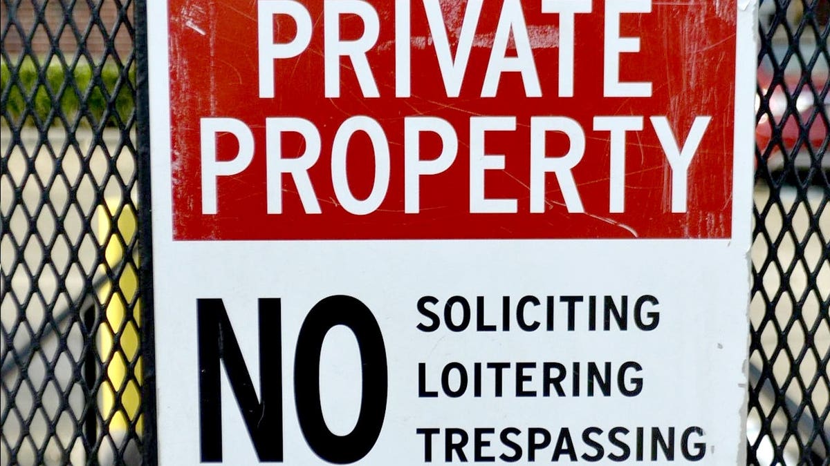 A no-trespassing sign on a fence.