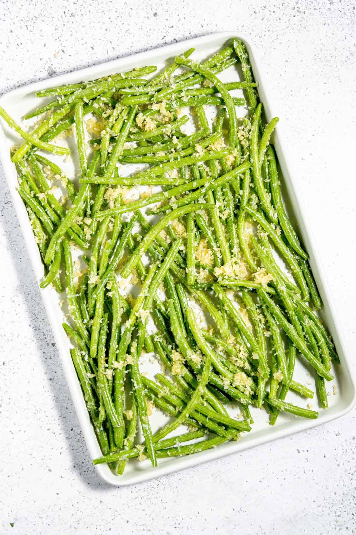 Roasted green beans on a white plate.