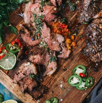 sliced picanha on a cutting board with sliced peppers