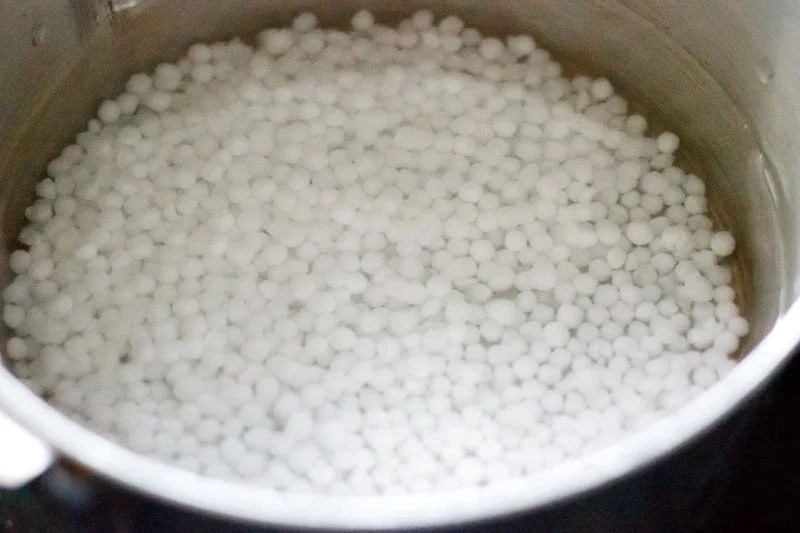 Rinsed sabudana added to water in a saucepan.