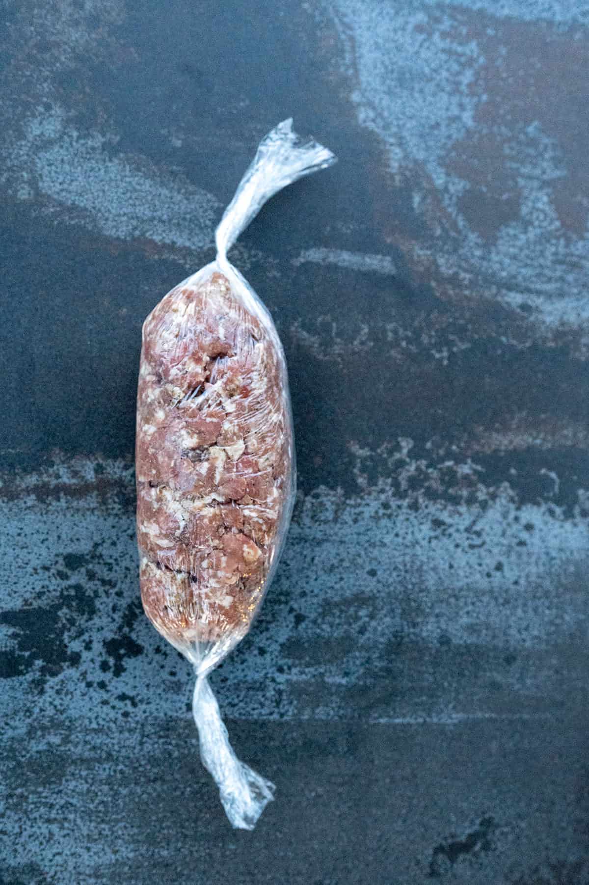 plastic wrap around breakfast sausage with twisted ends.