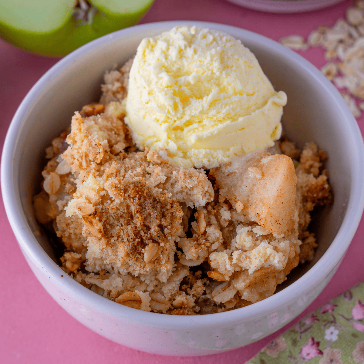 A bowl of gluten free apple crumble with a scoop of ice-cream on top.