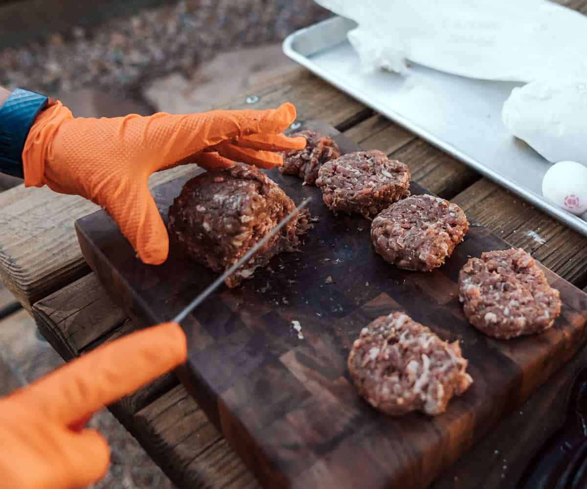 using knife to slice sausage log into patties.