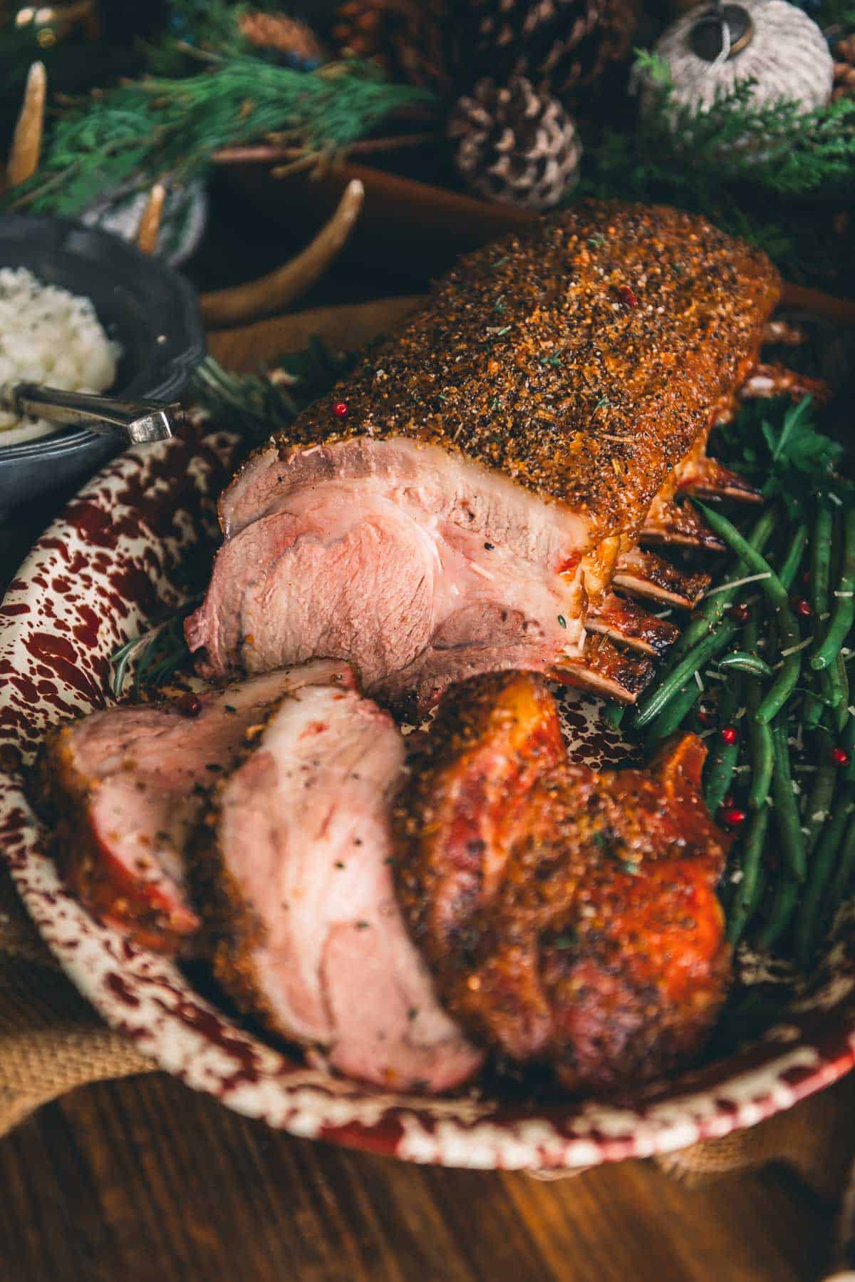 A plate of smoked pork and green beans on a wooden table.