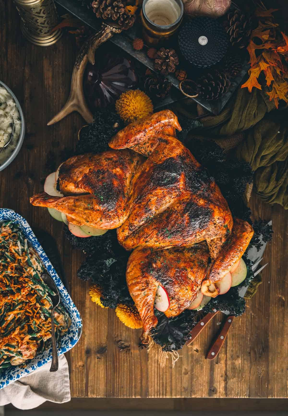 Golden roasted spatchcock turkey on a serving platter with sides.