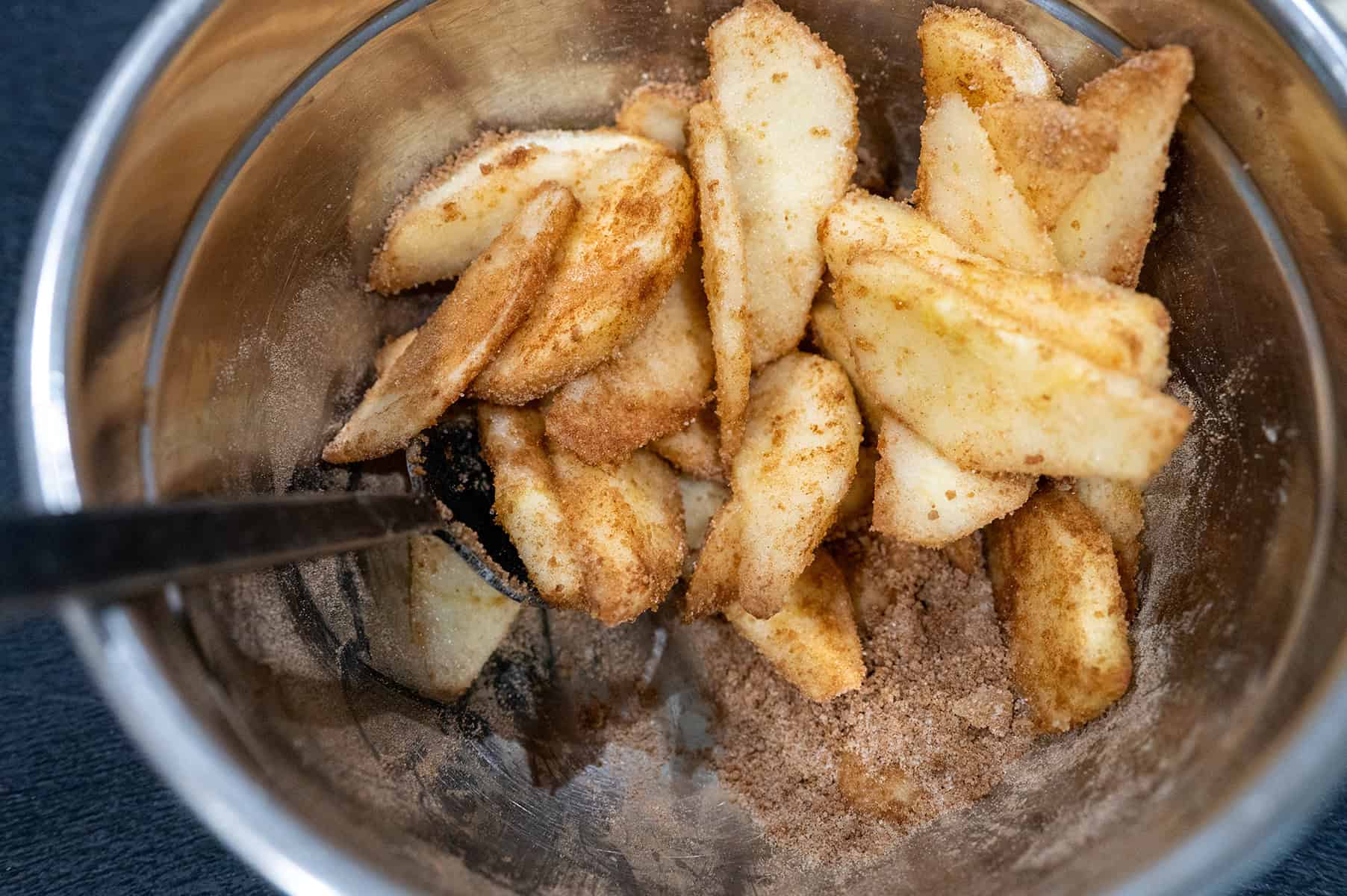 Apples in bowl with sugar, spices and flour.