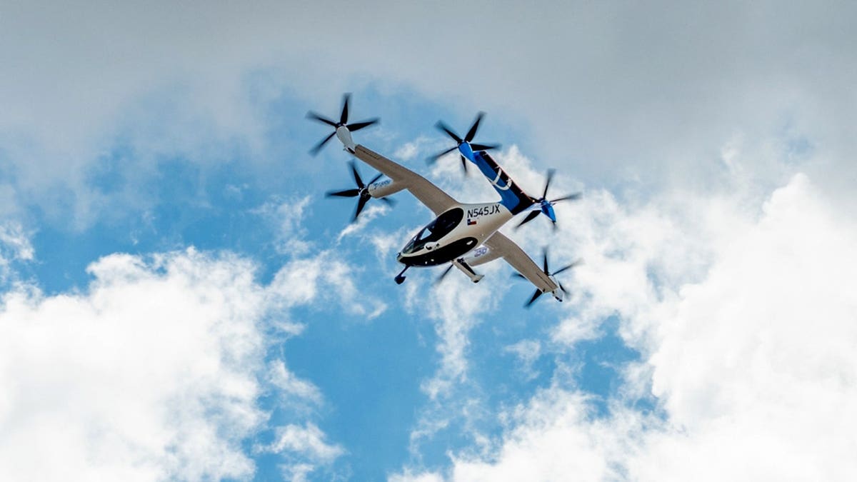An air taxi flying among clouds.