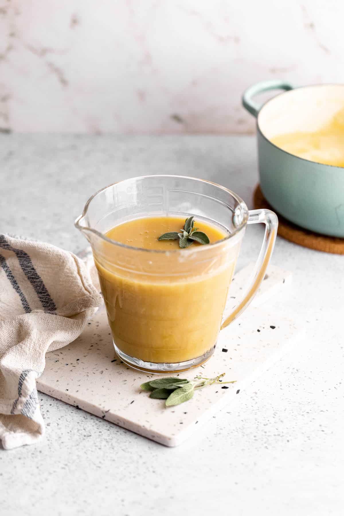 Measuring cup filled with velvety gravy.