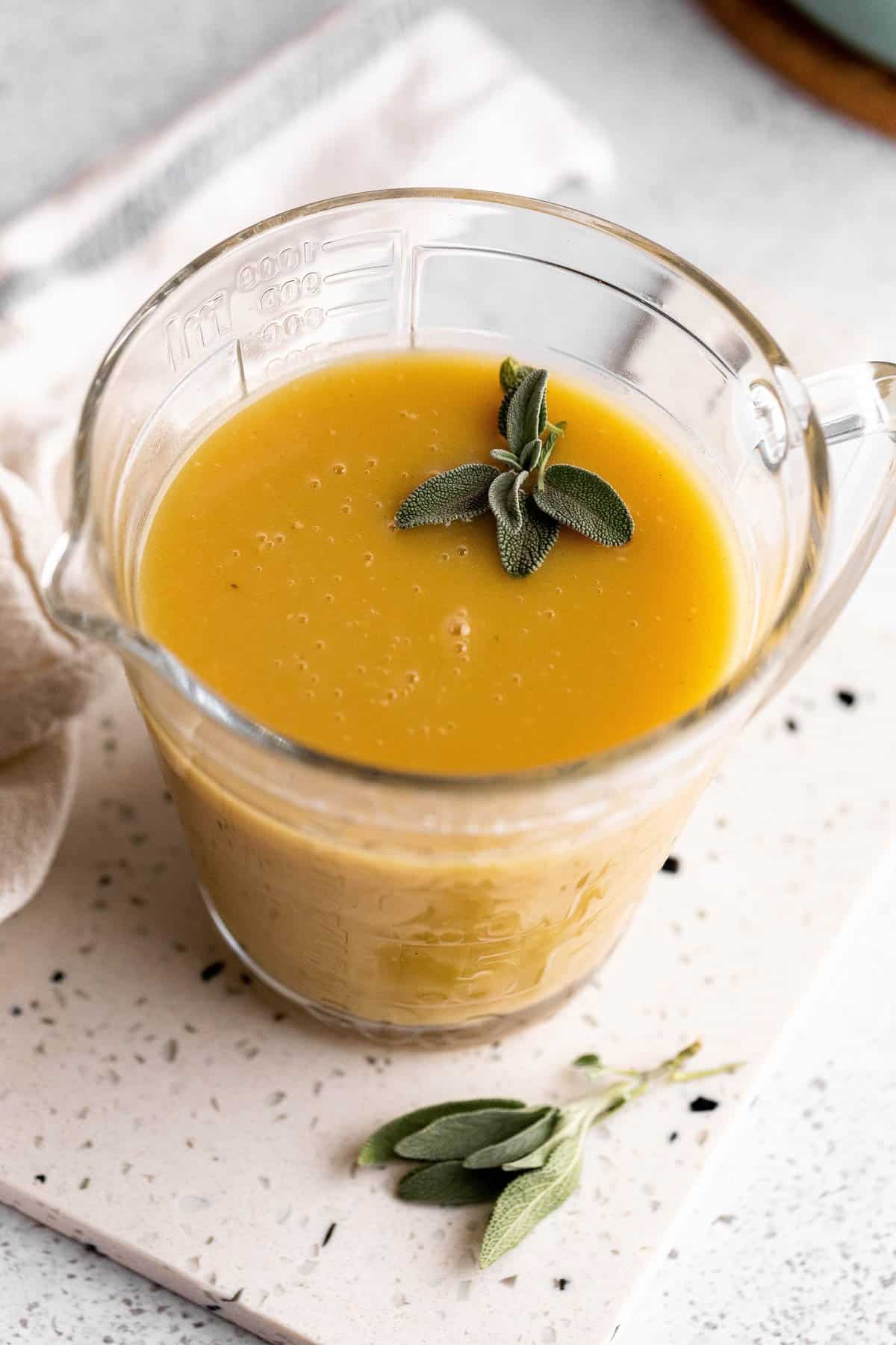 Close up of the gravy to show no clumps and fresh sage leaves on top. 