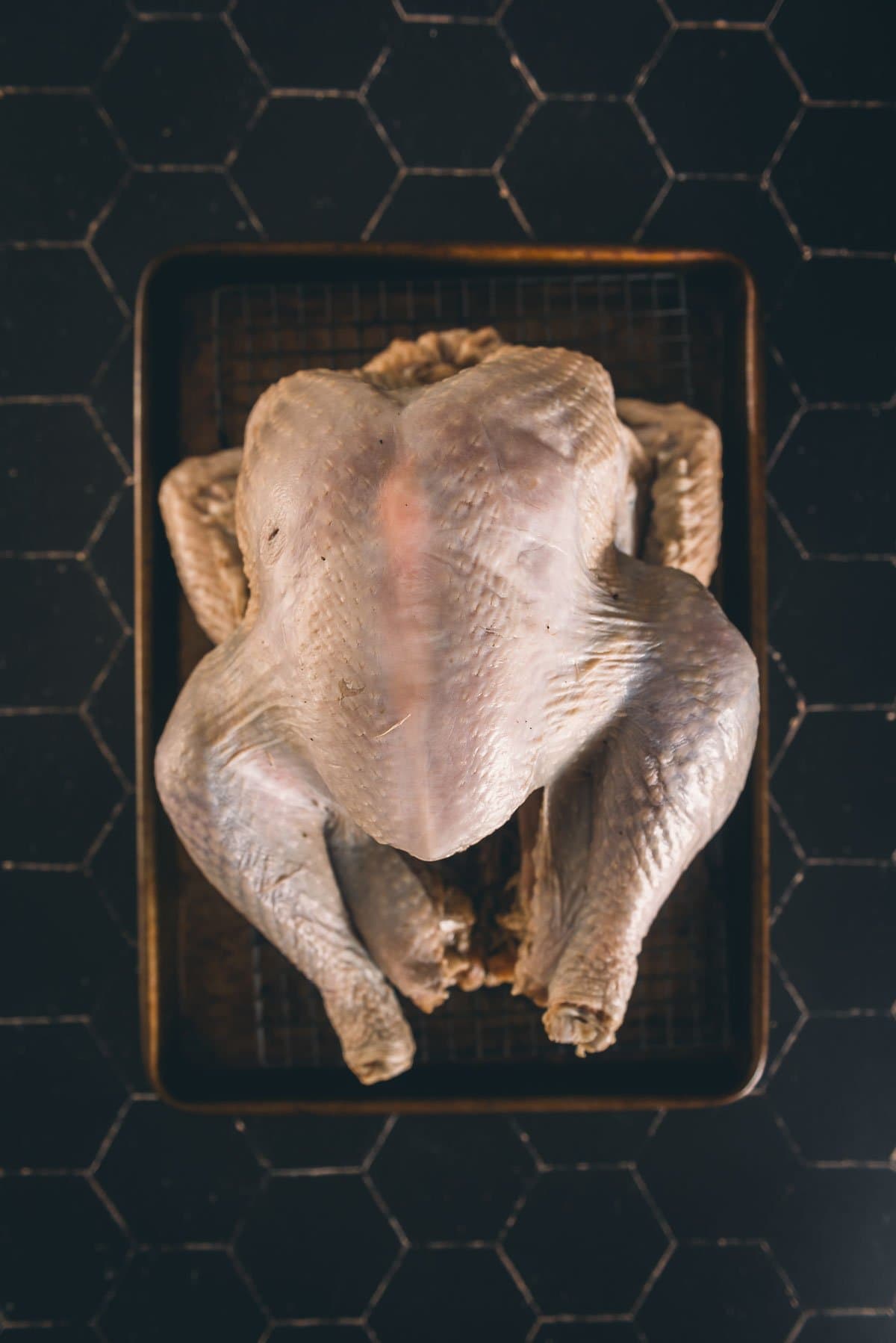 Turkey after being wet brined on a wire rack waiting to be cooked.